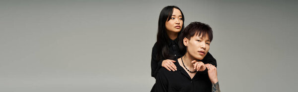 A fashionable couple showcases their bond through intimacy and style in a contemporary backdrop.