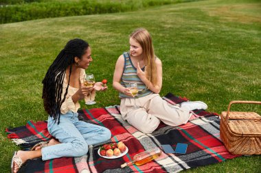 Güzel bir lezbiyen çift parkta rahat bir piknik yaparken kahkaha ve sevgiyi paylaşır..