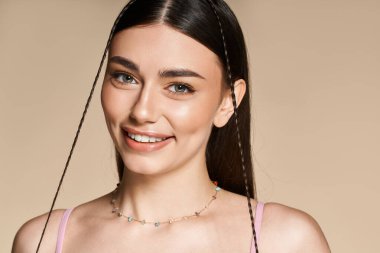 Genç bir kadın, güneş yanığı teniyle, ışıl ışıl gülümsemesiyle ve şık aksesuarlarıyla, yazı kucaklıyor..