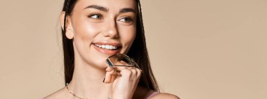 Güneş gözlüklü neşeli genç bir kadın, güneş ışığını kucaklarken gülümsüyor.