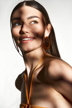 Neşeli genç bir kadın güneşlenir, güneşlenir, güzel güneşlenir ve yaz tarzını sergiler..