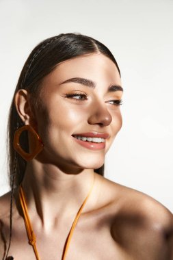 Güzel genç bir kadın yaz güneşinin tadını çıkarıyor. Güneş yanığı ve neşeli bir ifade sergiliyor..