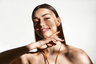 Güneş yanığı tenli genç bir kadın neşeyle gülümser, kaygısız bir yaz havası sergiler..