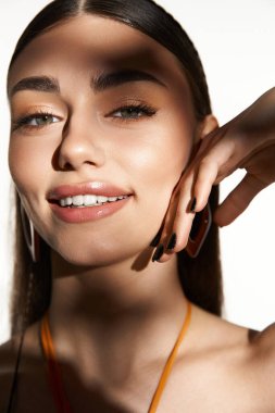 Parlak güneş ışığı, yaz sıcağını kucaklayan genç bir kadının neşeli ifadesini vurgular..