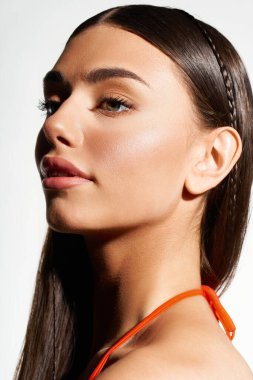 Genç bir kadın güzel bronz teniyle ve kendinden emin ifadesiyle hava atarken parlak yaz titreşimleri yayılıyor..