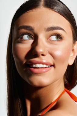 Güneş yanığı tenli genç bir kadın önlerindeki yaz günlerinin sıcaklığını kucaklayarak ışıl ışıl gülümsüyor..