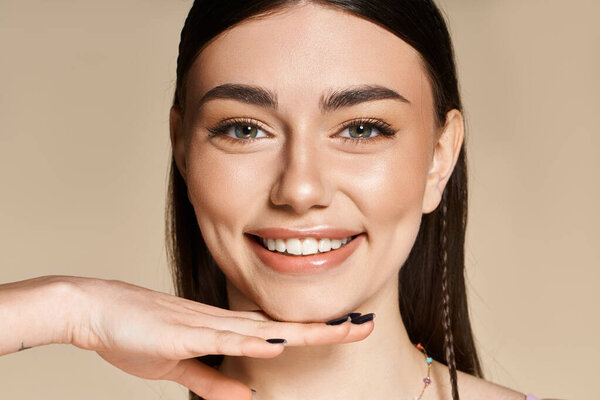 Молодая женщина наслаждается летним солнцем, демонстрируя свой здоровый загар и игривый дух, улыбаясь.