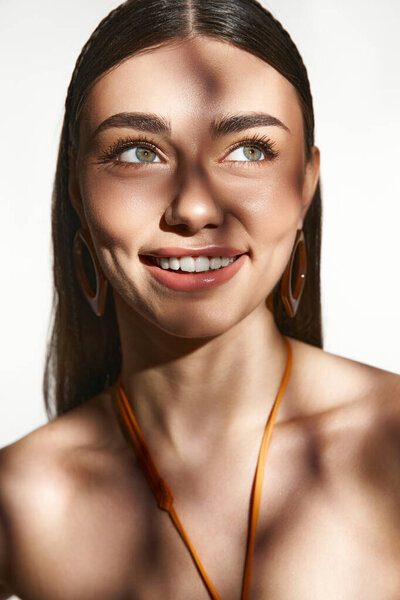 Молодая женщина с загаром ярко улыбается, улавливая суть летнего тепла и радости.