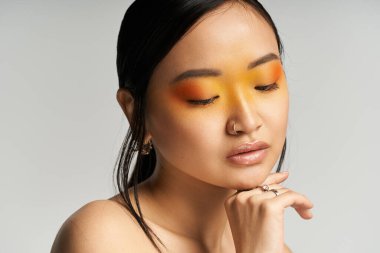 Hareketli makyajlı kendine güvenen genç bir kadın ev ortamında yüzünü sergiliyor..