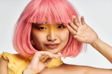 Pembe saçları olan genç ve güzel bir kadın oyuncu tarzını ve özgüvenini sergiliyor..