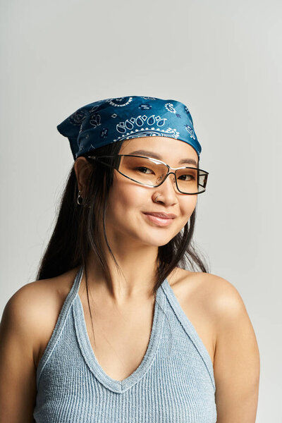 A young beautiful asian woman showcases her style with a bandana while smiling confidently.