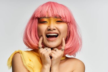 Pembe saçlı neşeli kadın neşeli bir ortamda ışıl ışıl gülümsüyor, neşe saçıyor.