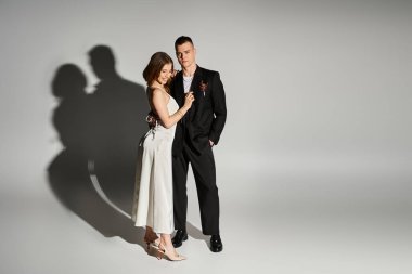 Genç gelin, yakışıklı damadına gülümser. Şık bir atmosferde hem sevgi hem de zarafet saçar..