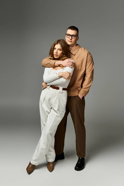 Стильная пара глубоко обнимается в шикарной атмосфере, подчеркивая их связь.