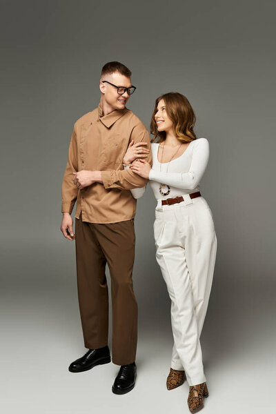 Прекрасный жених и невеста разделяют романтический момент вместе, одетые в стильные наряды.