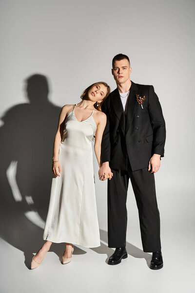 Красивая невеста и жених держатся за руки, источая романтику в современной, элегантной атмосфере.