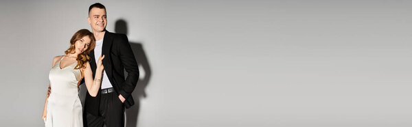 Beautiful bride and groom pose together, exuding love and elegance against a minimalist backdrop.