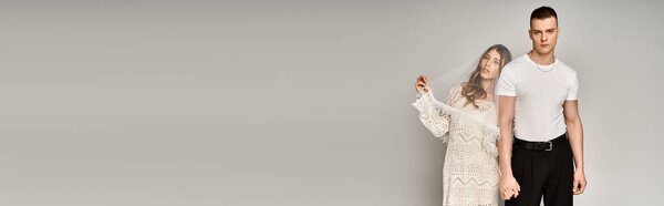 Beautiful bride and groom stand together, exuding elegance and romance in a stylish backdrop.