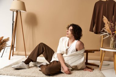 İyi görünümlü genç bir adam yaz kıyafetiyle poz verir. Stüdyoda oyuncu tarzını sergiler..