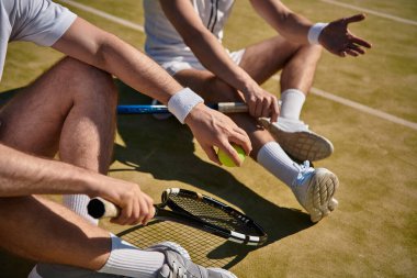Parlak yaz güneşi altında enerjik bir tenis maçından sonra dinlenen oyuncuların kesilen sahneleri.