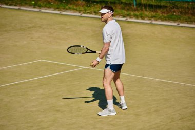 Beyazların spor kıyafetleri içinde odaklanmış bir sporcu tenis kortuna karşı harekete geçmeye hazır..