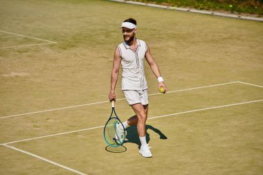 Yetenekli bir oyuncu güneşli bir yaz gününde tenis oynarken atletizm sergiliyor..