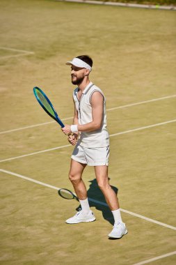 Beyaz spor giyimli yetenekli bir oyuncu etkileyici bir ters vuruş yaparken dikkatle odaklanır..