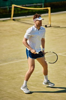 Odaklanmış oyuncu sıcak bir yaz gününde tenis kortunda becerilerini sergiliyor.