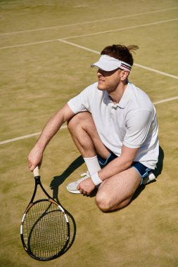 Yetenekli bir oyuncu sıcak bir yaz gününde kortta hizmet etmeye hazırlanırken çömelir..