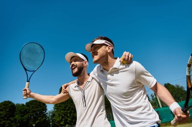 İki arkadaş heyecan verici bir tenis maçından sonra neşeli bir anı kutluyor..