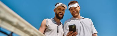 İki mutlu genç adam tenis oynuyor, gülüyorlar yaz öğleden sonralarının keyfini çıkarırken, afiş