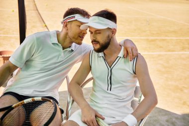 Genç eşcinsel bir çift tenis kortunda dinlenirken birlikte eğlenceli anlar geçirir..