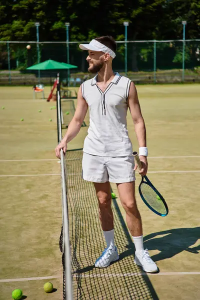 Yetenekli bir oyuncu, güneşin altında tenis oynamaya hazır bir şekilde sahada güvenle duruyor..