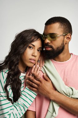 Bir çift birbirine sevgiyle sarılıyor, modaya uygun kıyafetlerini ve sevgilerini sergiliyor..