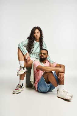 Çiftler otururken moda kıyafetlerini ve derin bağlantılarını sergilerler..