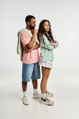 Moda bir çift birlikte poz verir, çağdaş uzayda güven ve tarz yayarlar..