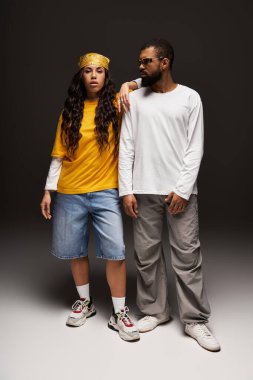 Çift, özgün stil ve bağlantılarını kucaklayarak çağdaş bir stüdyoda güven içinde duruyor..