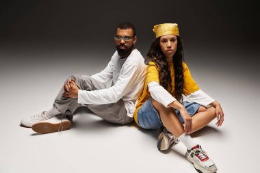 Şık bir çift sırt sırta oturur, moda anlayışlarını ve bağlantılarını vurgularlar..