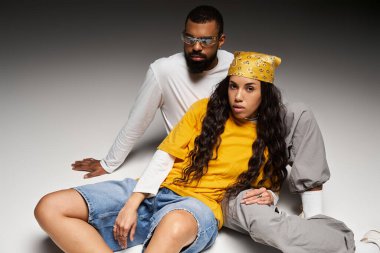 Bir çift modern bir arkaplanda poz verirken eşsiz tarzlarını ve sevgilerini sergiliyor..