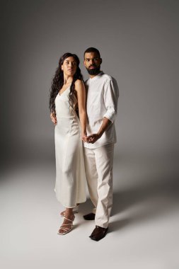 Şık bir çift, kıyafetlerini ve kimyalarını vurgulayarak kendilerine güvenerek poz verir..