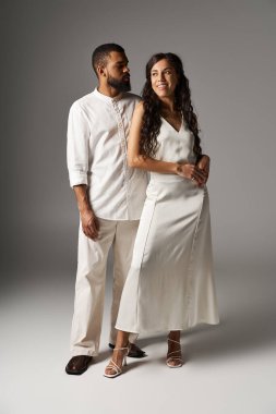 Şık kıyafetler giymiş çift, asgari arkaplanda aşk ve romantizmi temsil ediyor..