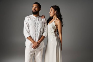 Şık bir erkek ve zarif bir kadın, bir stüdyo ortamında şık kıyafetlerle aşklarını sergilerler..