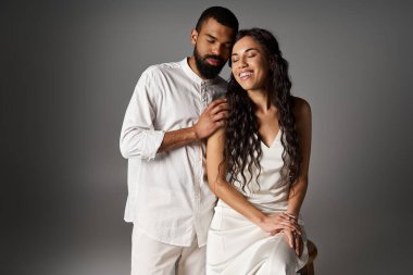 Çift, sakin bir stüdyo ortamında şık giyinip, sevgilerini ve ilişkilerini ifade eder..