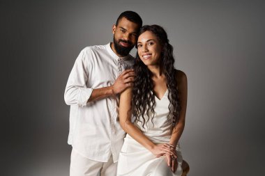 Modern atmosferde sevgi ve mutluluk saçan şık bir çift birbirine yakın poz verir..