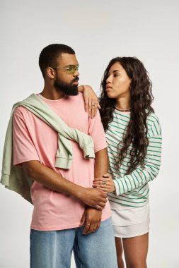 Bir çift, canlı kıyafetlerle aşk ve moda sergiliyor ve stüdyo ortamında sevgi paylaşıyor..