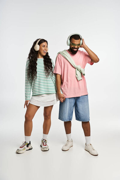 Модная пара делится моментом, слушая музыку и демонстрируя свои уникальные стили.