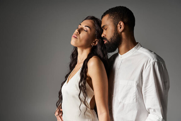 A couple stands closely together, embodying romance and style as they share a tender moment.