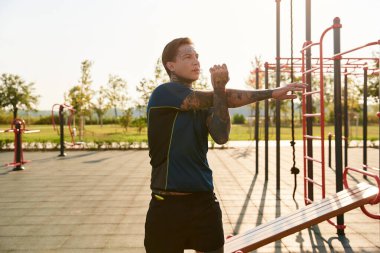 Yakışıklı genç bir adam altın saat boyunca güzel bir parkta ferahlatıcı bir yürüyüş yapar..