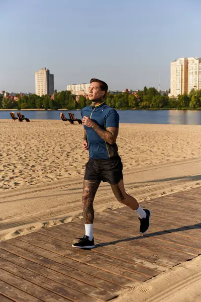 Yakışıklı genç adam, sıcak güneş ve temiz havayla ıslanmış, deniz kenarında kumlu bir yolda koşar..