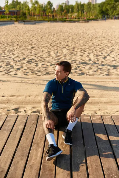 Genç, yakışıklı bir adam plajdaki tahtalarda dinleniyor, güneşin sıcaklığında sırılsıklam oluyor..